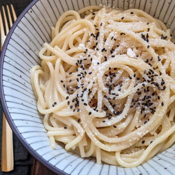 Schüssel mit Spaghetti in einer Bütter-Miso-Soße. Darüber etwas Parmesan und schwarzer Sesam
