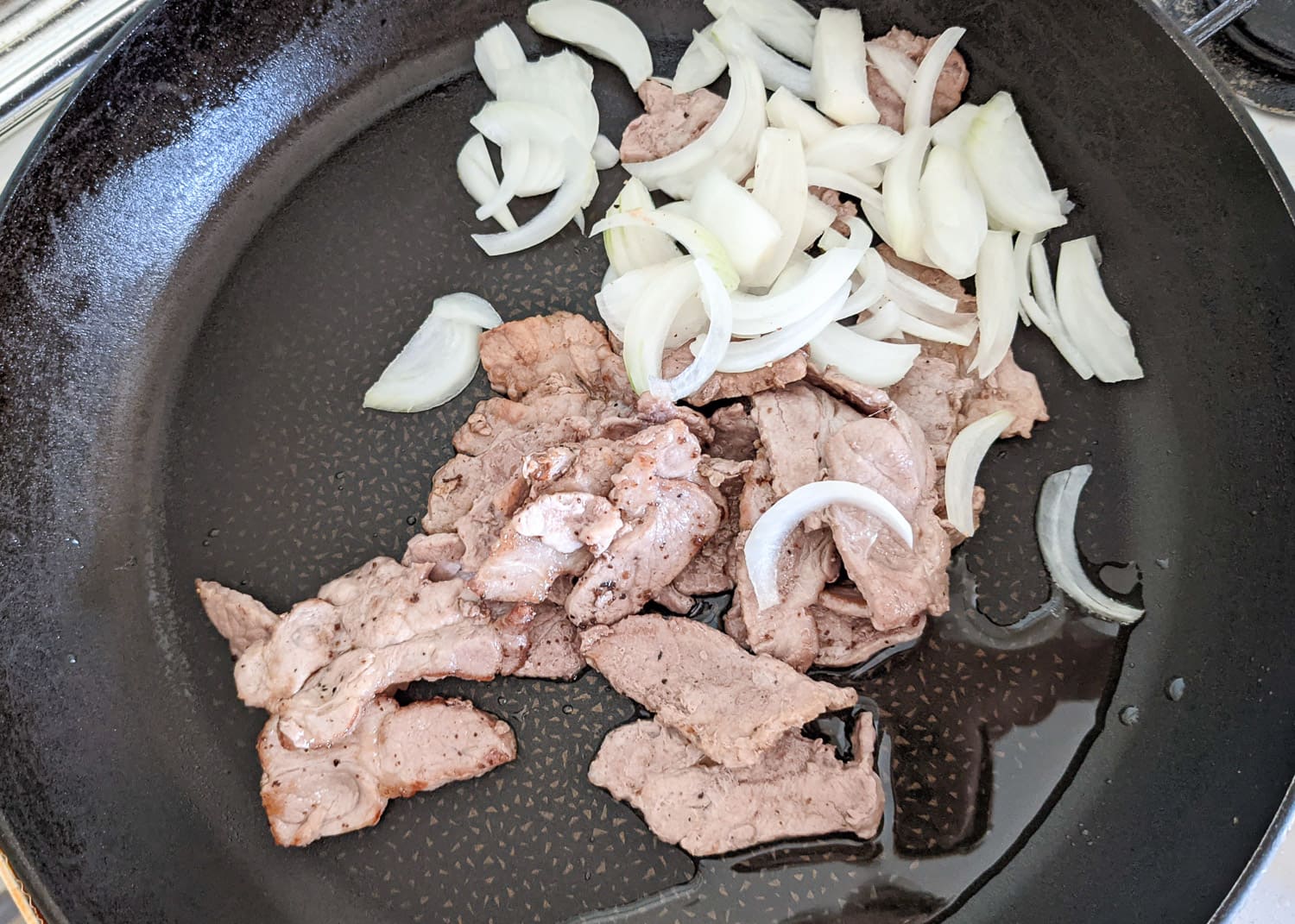 Erst die Zwiebeln glasig werden lassen in der Pfanne, dann Fleisch wieder hinzu und dann die Soße.