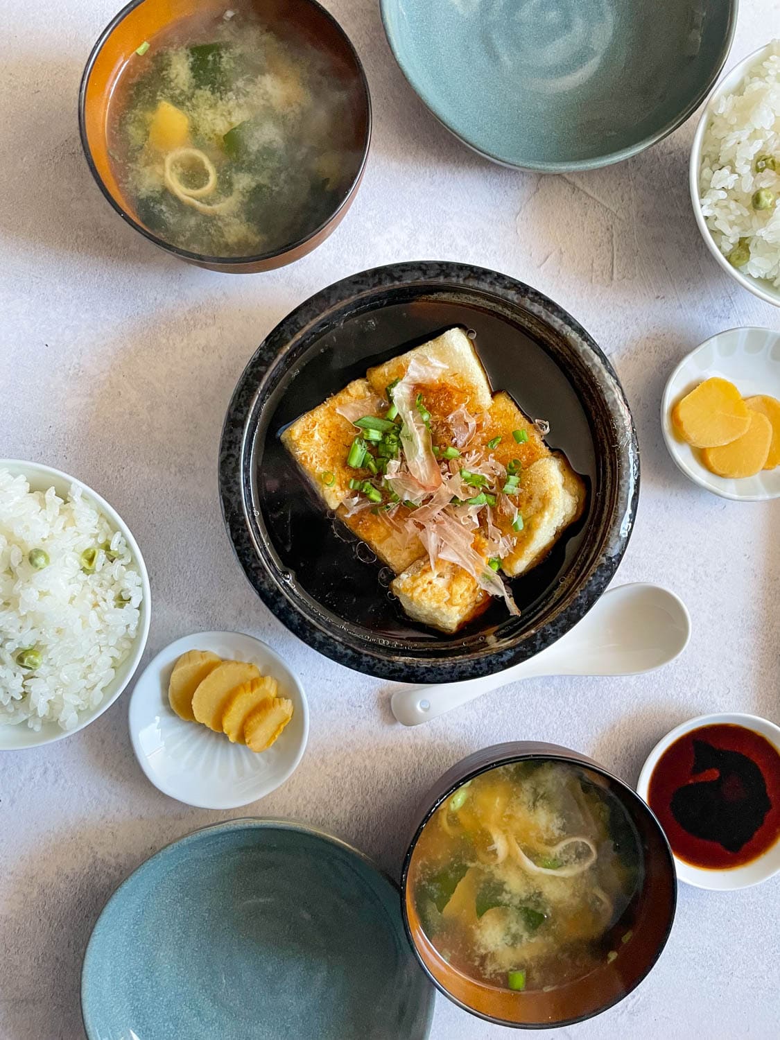 Agedashi Tofu am Taisch mit vielen kleinen Schalen japanischer Gerichte