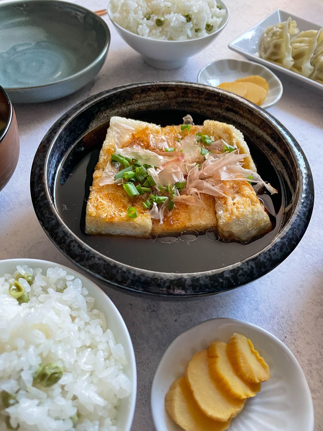 Agedashi Tofu in Schale angerichtet mit Beilagen.