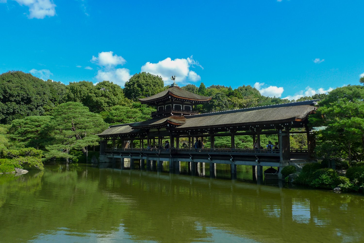 Eine chinesische überdachte Brücke über einen Teich im Garten des Heian-jingu