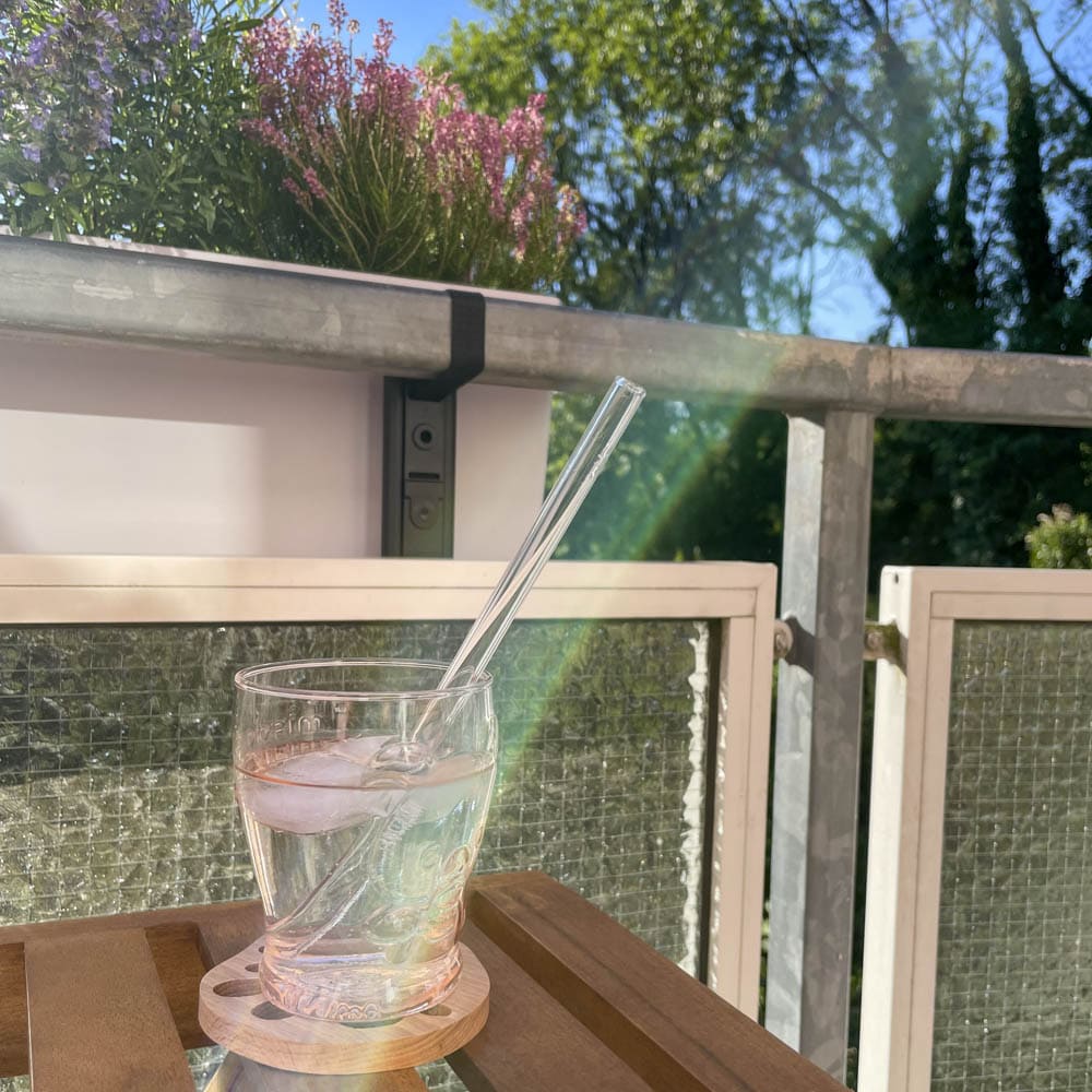 Rosa Glas mit Glasstrohhalm am Balkon mit Ume-Sirup und Sprudelwasser